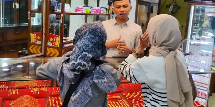 Pemilik Toko Emas Melati Indah, Rico Fernanda sedang melayani pembeli di Pasar Raya Padang, Senin (7/4/2025). (Randi/Padeks)