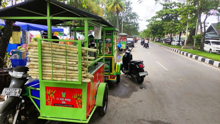 BAWA BERKAH: Pono, pedagang es tebu, terlihat sedang menunggu pembeli di Pantai Padang.(FAISAL K/PADEK)