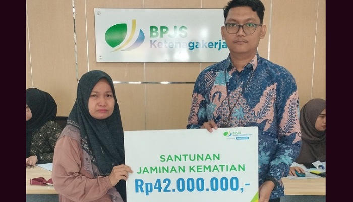 Kepala BPJS Ketenagakerjaan Cabang Solok, Maulana Anshari Siregar serahkan santunan kepada peserta BPJS Ketenagakerjaan atas nama Zul Alfian yang ahli warisnya menerima santunan JKM.