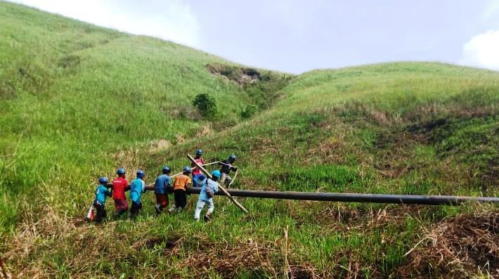 Ilustrasi Petugas PLN bergotong-royong saat proses pendistribusian material tiang listrik untuk pembangunan jaringan listrik di desa-desa sekitar Sentani, Kabupaten Jayapura, Papua.