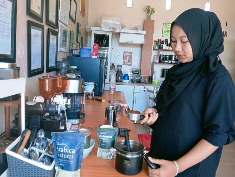 MAGNET BAGI PECINTA KOPI: Salah seorang karyawan Teras Kopi Pak Datuak sedang menyeduh kopi siap saji untuk pengunjung, kemarin.(ARDI/PADEK)