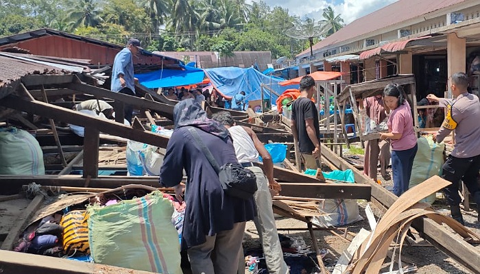 Pedagang membenahi puing-puing bangunan los Pasar Ampalu yang roboh, Sabtu (19/4/2025). (Foto Dok Wanag Muskinta)