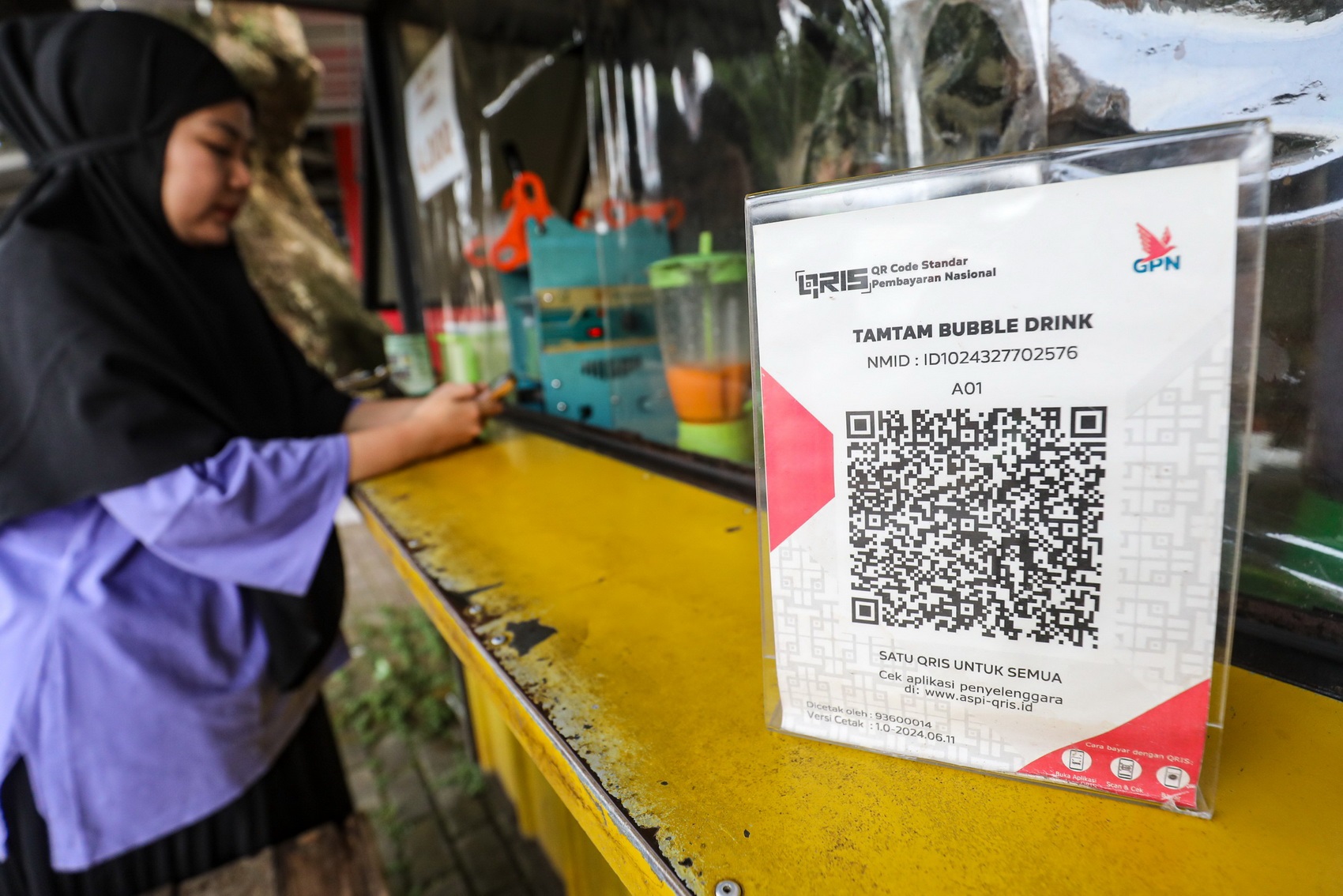 Pembeli melakukan pembayaran menggunkan QRIS di Depok, Jawa Barat, Senin (21/4/2025). Pemerintah Amerika Serikat (AS) menyoroti penggunaan Quick Response Indonesian Standard (QRIS) dan Gerbang Pembayaran Nasional (GPN) kala Pemerintah RI melakukan negosia