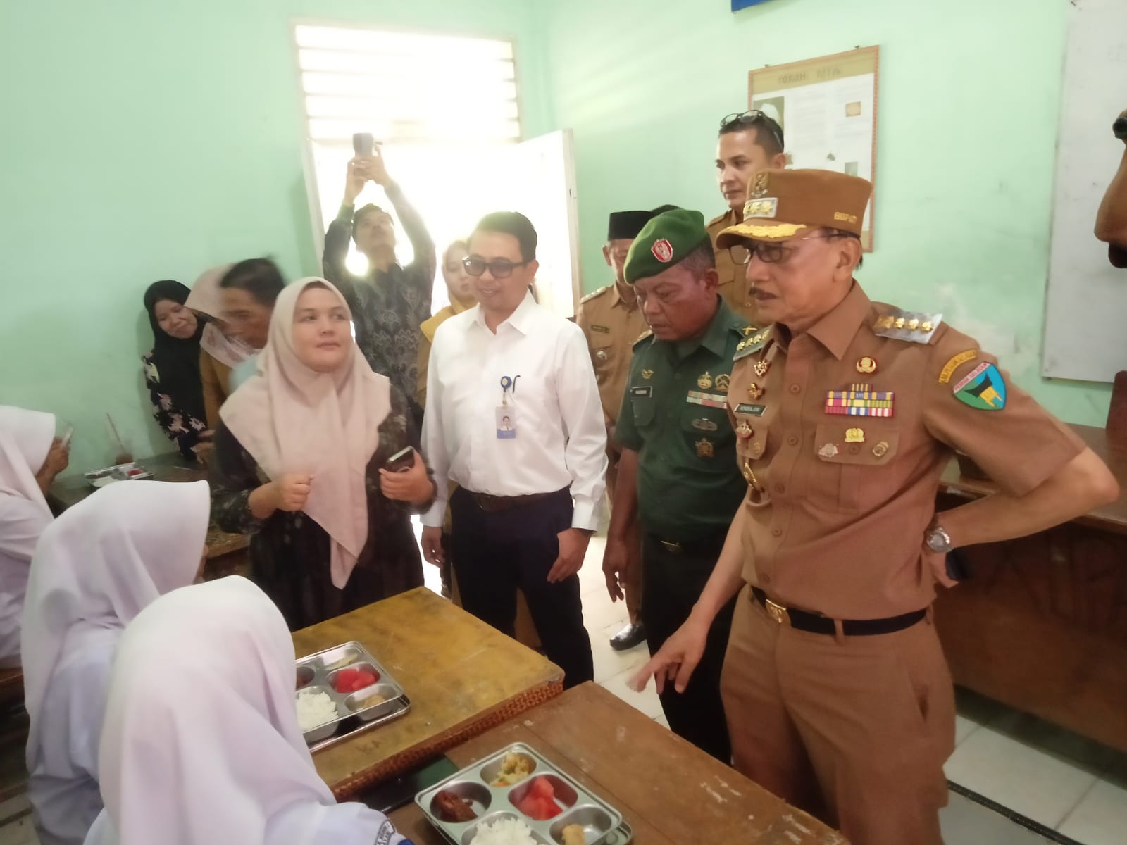 Bupati Pessel, Hendrajoni, dan Ketua Yayasan Tuah Cipta Berdaya, Okvina Juita, beserta rombongan terlihat di SMAN 2 Bayang melakukan peninjauan pemberian MBG. (dok.yon)