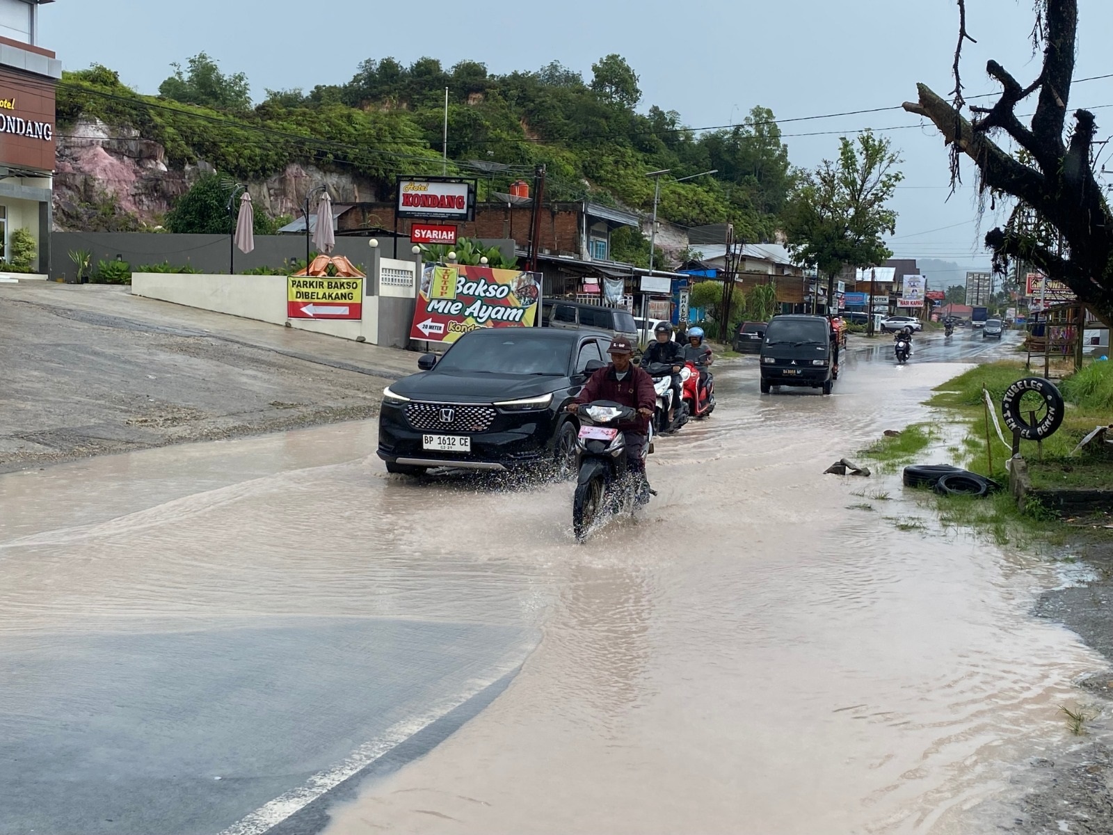 PERLU JADI PERHATIAN: Sejumlah kendaraan berhati-hati saat melintasi genangan air di Jalan Sumbar&ndash;Riau, tepatnya di KM 9 Sarilamak, Kabupaten Limapuluh Kota, Senin (28/4). (SY RIDWAN/PADEK)