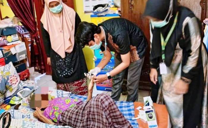 Dokter Warga sedang menangani pasien lansia di rumahnya. (dok humas pemko padang)