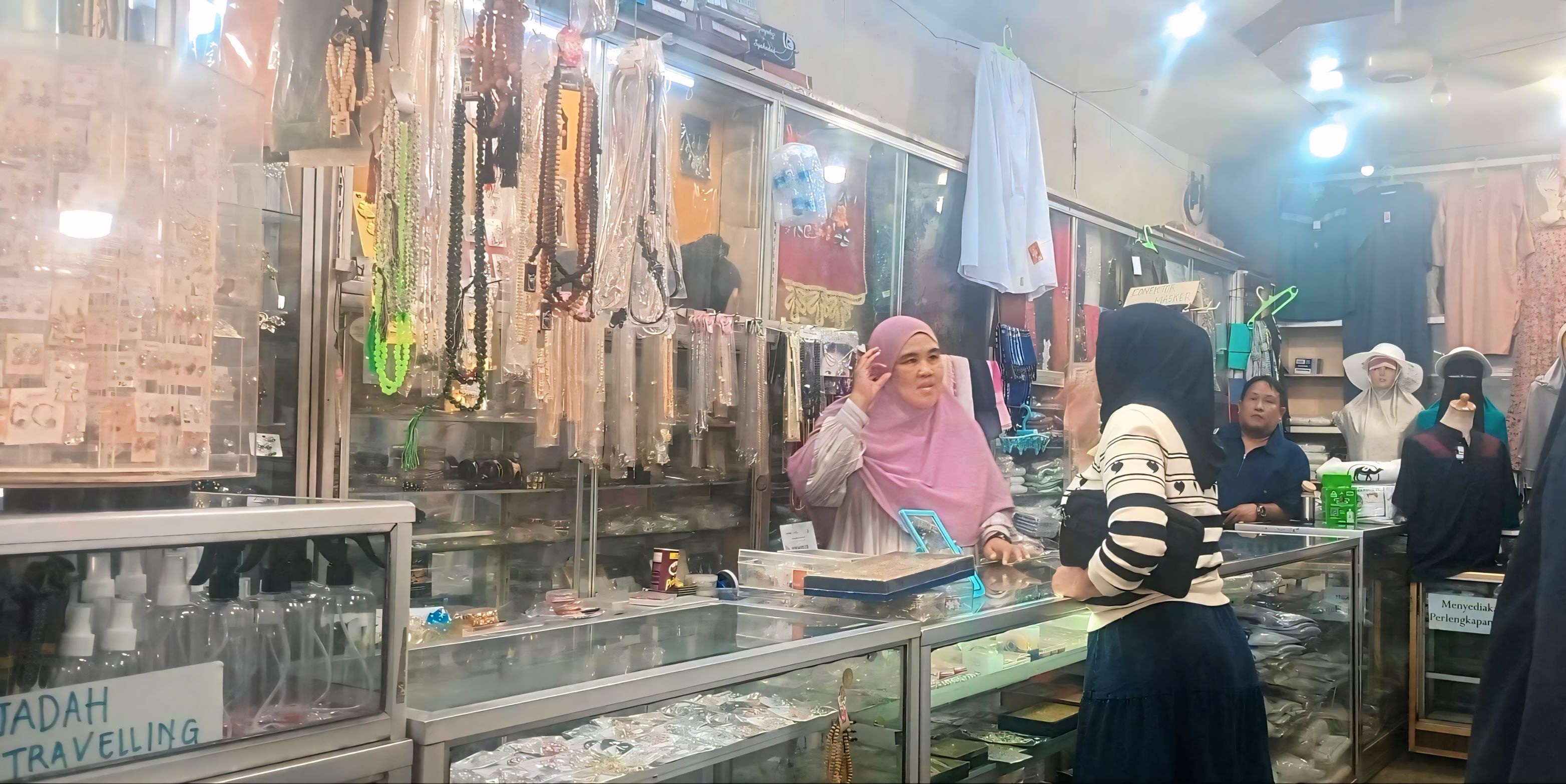 Salah seorang pedagang perlengkapan haji di Pasar Raya Padang sedang melayani pembeli, kemarin.
