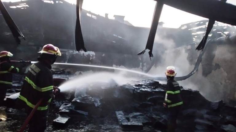 Personel Dinas Damkar Kota Padang melakukan pendinginan usai api kembali muncul di pabrik karet milik PT Teluk Luas, Selasa (20/5/2025).