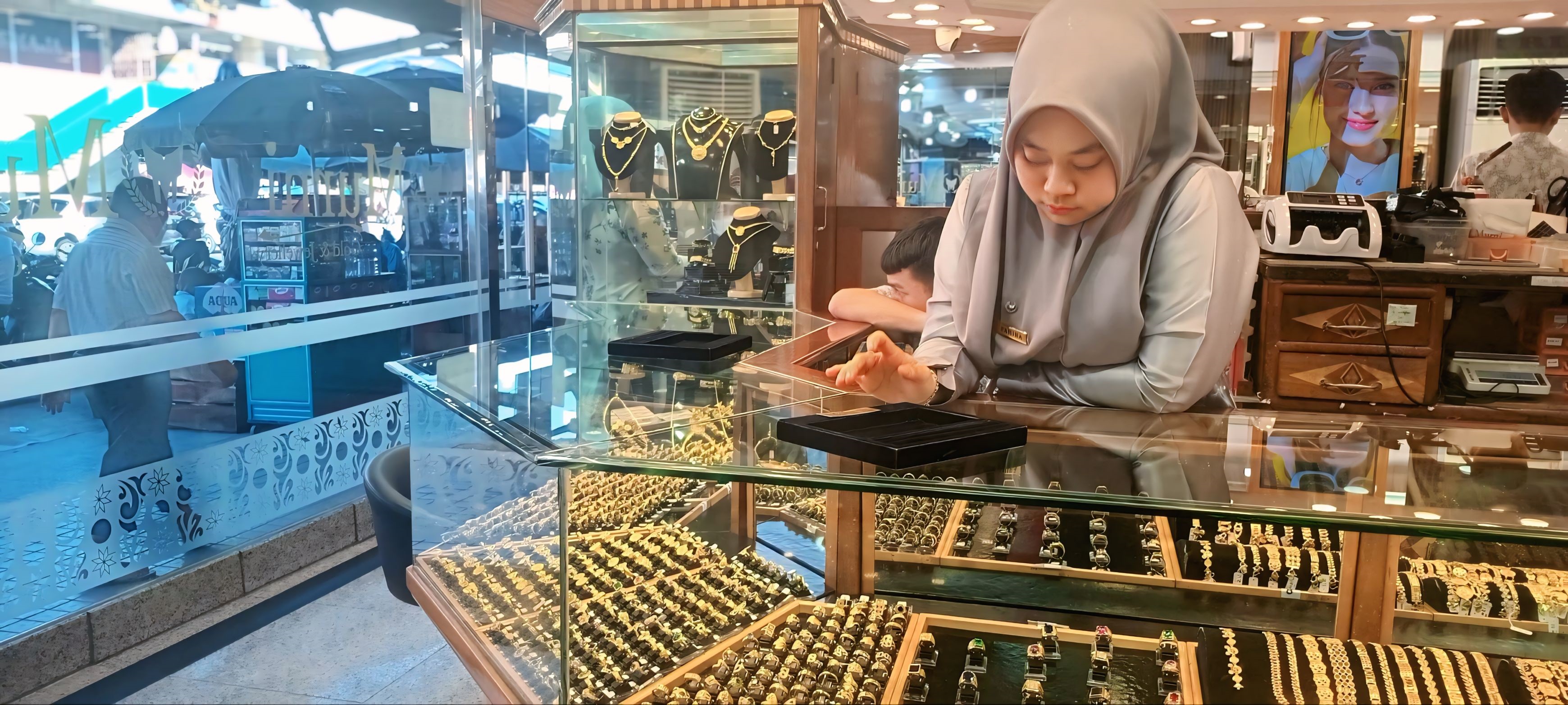 SILVINA/PADEK  TUNGGU PEMBELI: Salah seorang karyawan toko emas di Pasar Raya Padang sedang menunggu pembeli, Rabu (21/5).