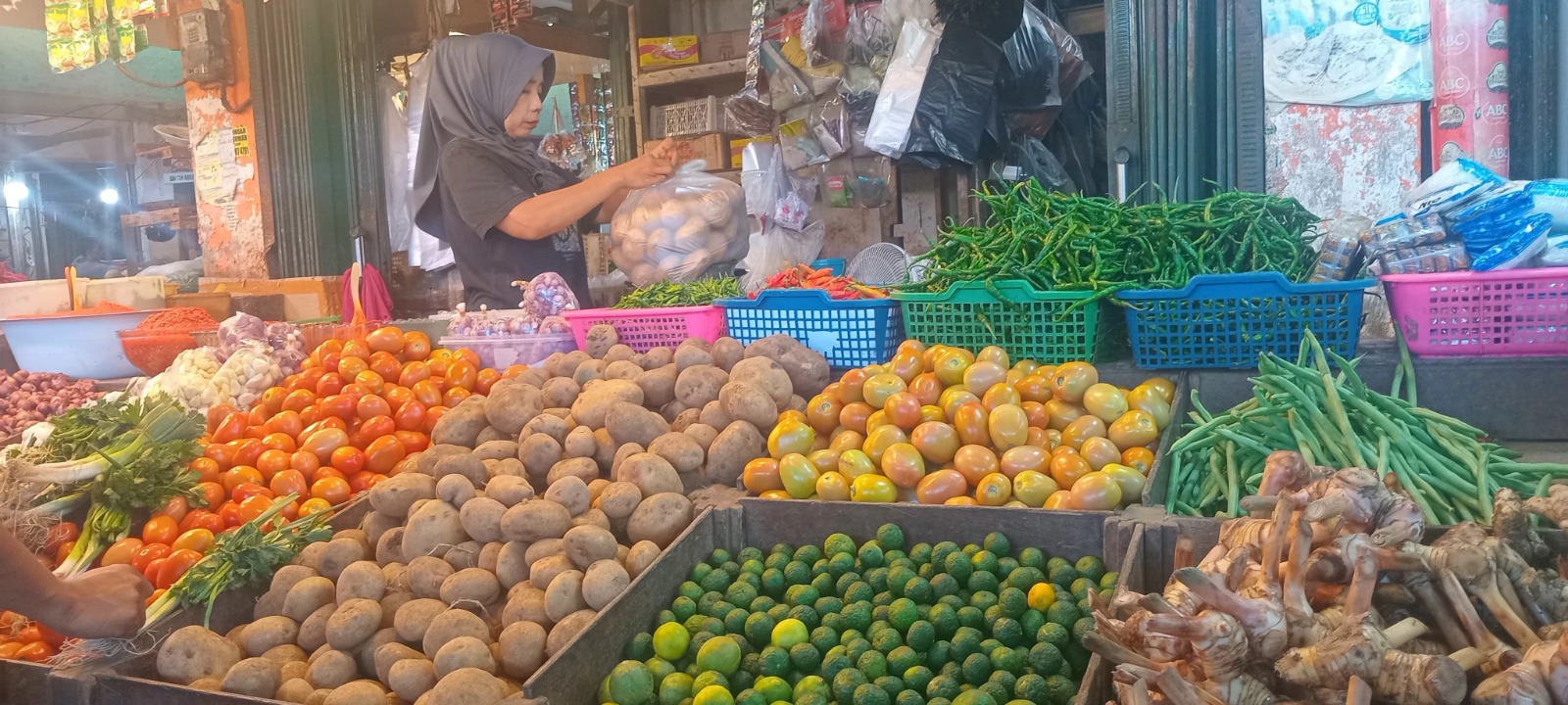 Pedagang kebutuhan pokok di Pasar Alai menunggu pembeli, Jumat (23/5).