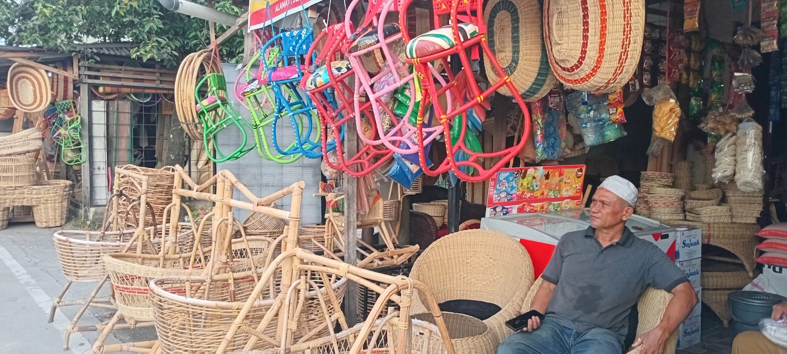 Pemilik toko furnitur rotan di Lubukbegalung sedang menunggu pembeli, kemarin.