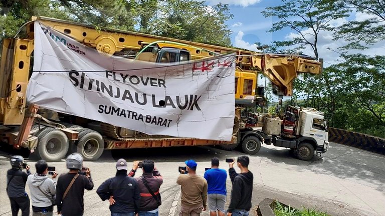 Truk-truk pengangkut alat berat mulai berdatangan pada Rabu (4/6/2025) ke lokasi proyek flyover yang menghubungkan Padang dan Solok, Sumatera Barat. (Foto: Sitinjaulauikchannel)