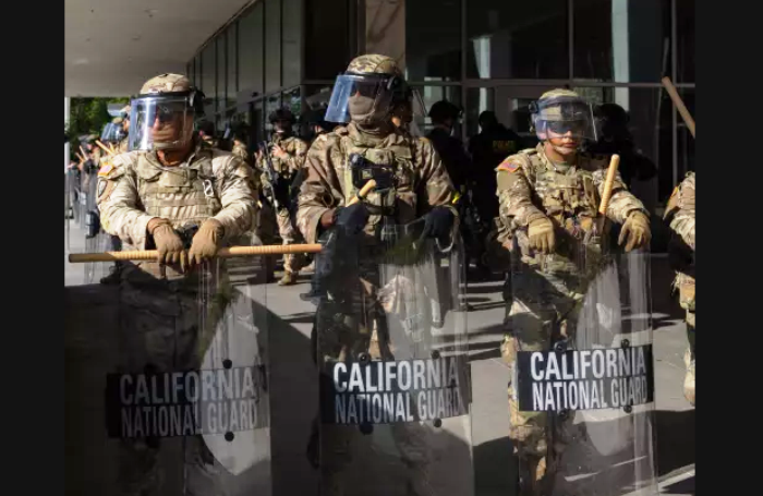 Petugas federal dan Garda Nasional melindungi gedung Federal di pusat kota Los Angeles akibat kerusuhan akibat penggerebekan imigrasi pada tanggal 10 Juni 2025 lalu. (Jason Armond/Los Angeles Times)