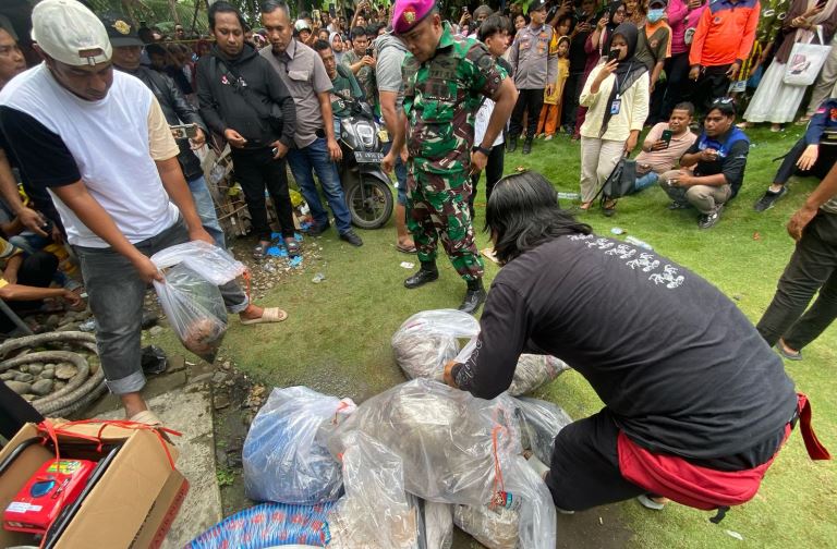 Petugas mengevakuasi kantong berisi barang bukti dari dalam sumur di belakang rumah terduga pelaku Wanda di Lakuak, Nagari Sungaibuluh, Kecamatan Batanganai, Kamis (19/6/2025).
