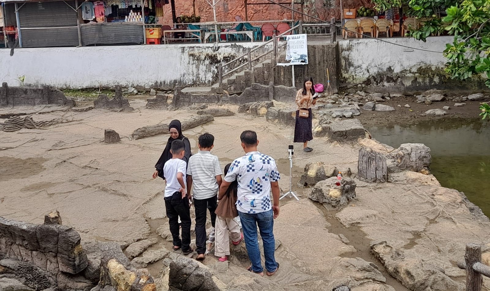 Para wisatawan berfoto di Batu Malin Kundang, Pantai Airmanis.