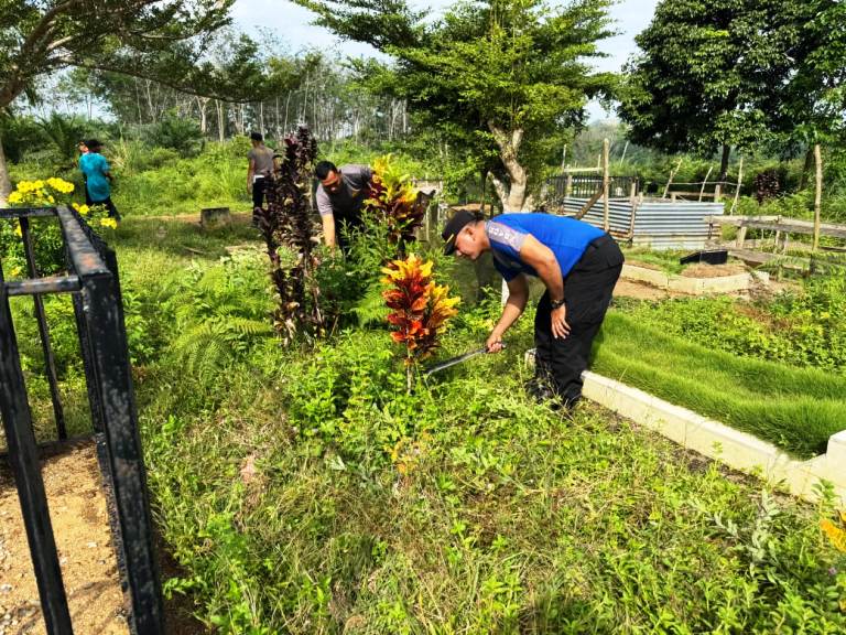 SINERGI: Kapolsek Pulaupunjung Iptu Azhamu Suwaril bersama jajaran dan warga bergotong royong membersihkan makam dalam kegiatan bakti sosial religi.(POLSEK PULAUPUNJUNG UNTUK PADEK)