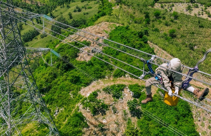 Ilustrasi petugas PLN melakukan pemeliharaan jaringan transmisi guna menjaga keandalan pasokan listrik kepada masyarakat.