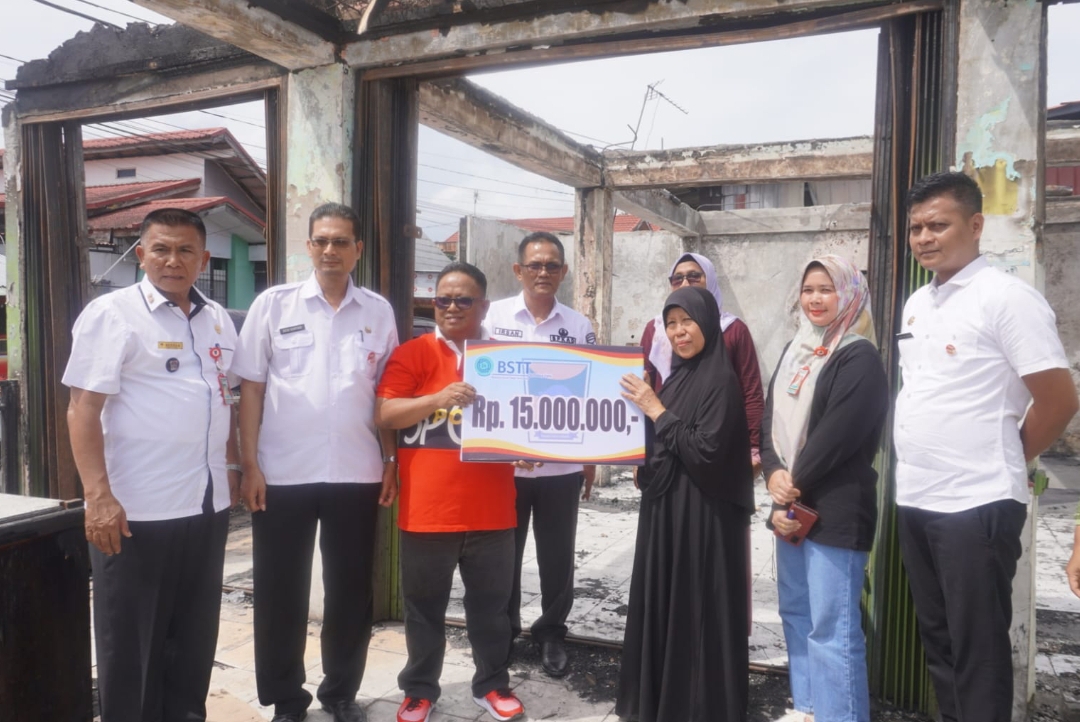 Camat Nanggalo, Amrizal Rengganis menyerahkan bantuan Pemko kepada korban kebakaran di Surau Gadang. (Foto: IST)