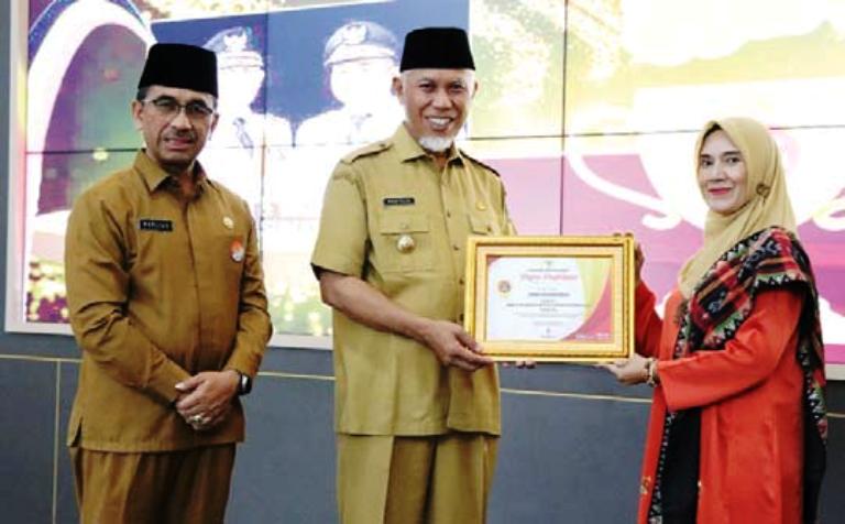 REWARD: Kepala SMKN 3 Payakumbuh Dra. Wismarni, MM ketika menerima Anugerah Gubernur Sumbar, pelaksana kurikulum Satuan Pendidikan (KSP) 10 terbaik tingkat SMKN Sumbar.(TIM LAMAN GURU)