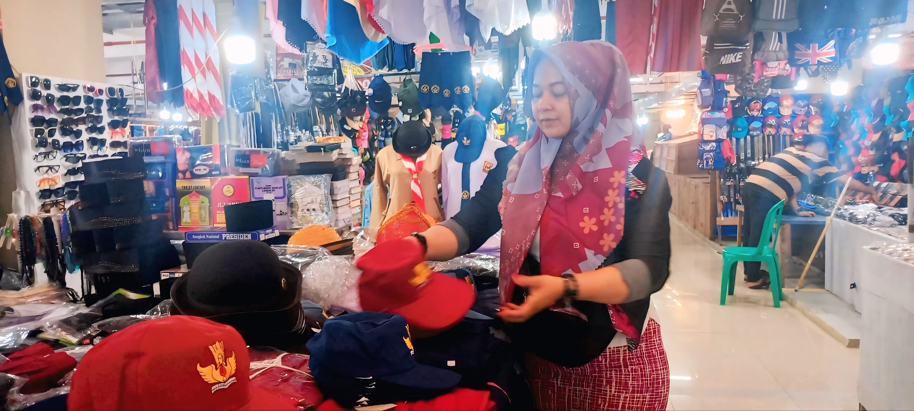 Salah seorang pedagang seragam sekolah di Pasar Raya Padang sedang menunggu pembeli di tokonya, kemarin.