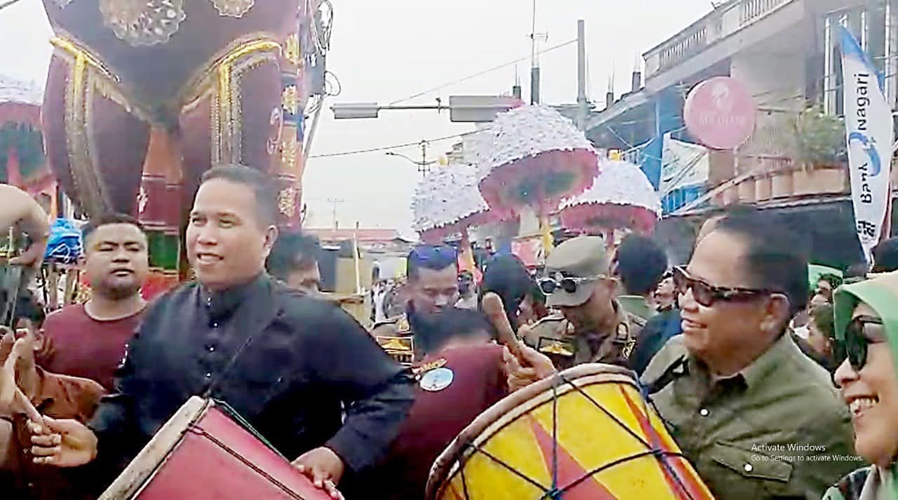 SEMARAK: Wakil Wali Kota Pariaman Mulyadi bersama pengusaha asal Piaman, Basrizal Koto, memainkan gandang tasa saat prosesi Tabuik Naiak Pangkek, Minggu (6/7).(PEMKO PARIAMAN UNTUK PADEK)