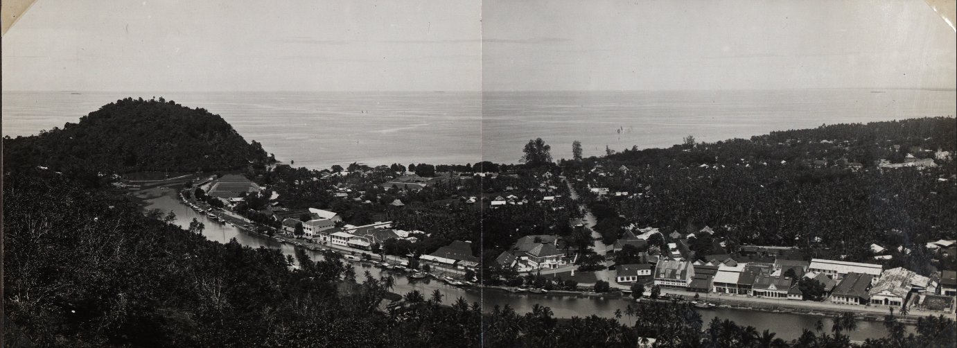 Lanskap Kota Padang sekitar 1920-an. Tampak bangunan dari beton berdiri di sekitar Handelskade (kini Jl. Batang Arau), sementara di sekelilingnya masih terlihat rumah-rumah kayu beratap rumbia.