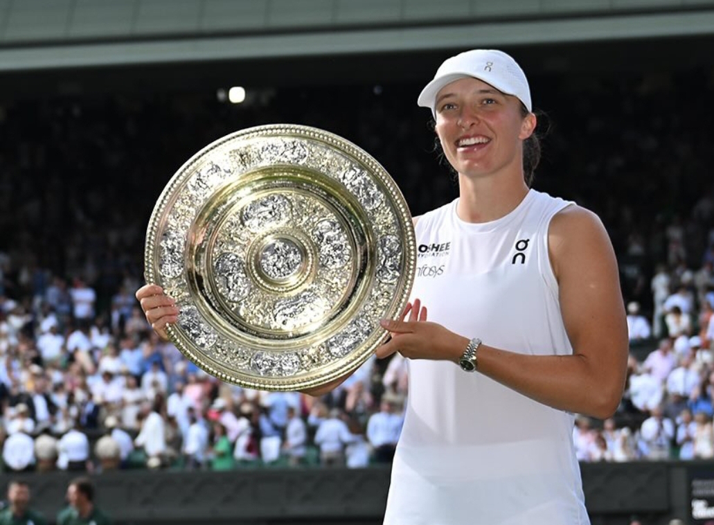 Iga Swiatek mengangkat trofi Wimbledon 2025 setelah mengalahkan Amanda Anisimova dengan skor 6-0, 6-0 di final. (Foto: Instagram/ @wimbledon)
