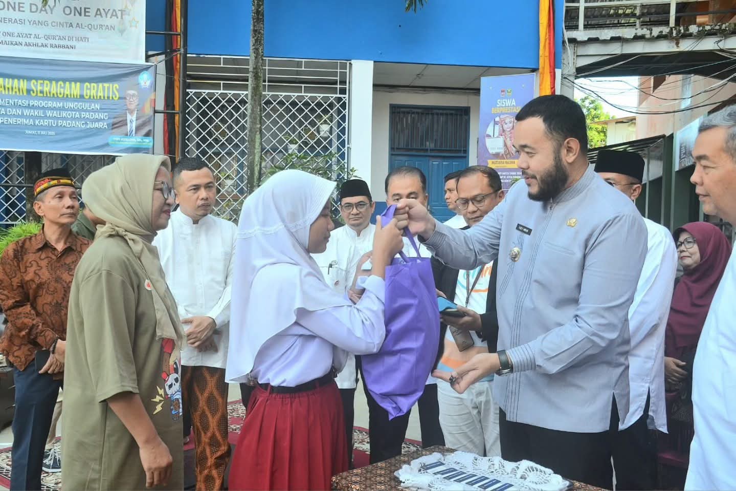PEDULI: Wako Padang Fadly Amran menyerahkan seragam gratis kepada peserta didik baru di SMPN 2 Padang, Jumat (11/7).(PROKOPIM PADANG)