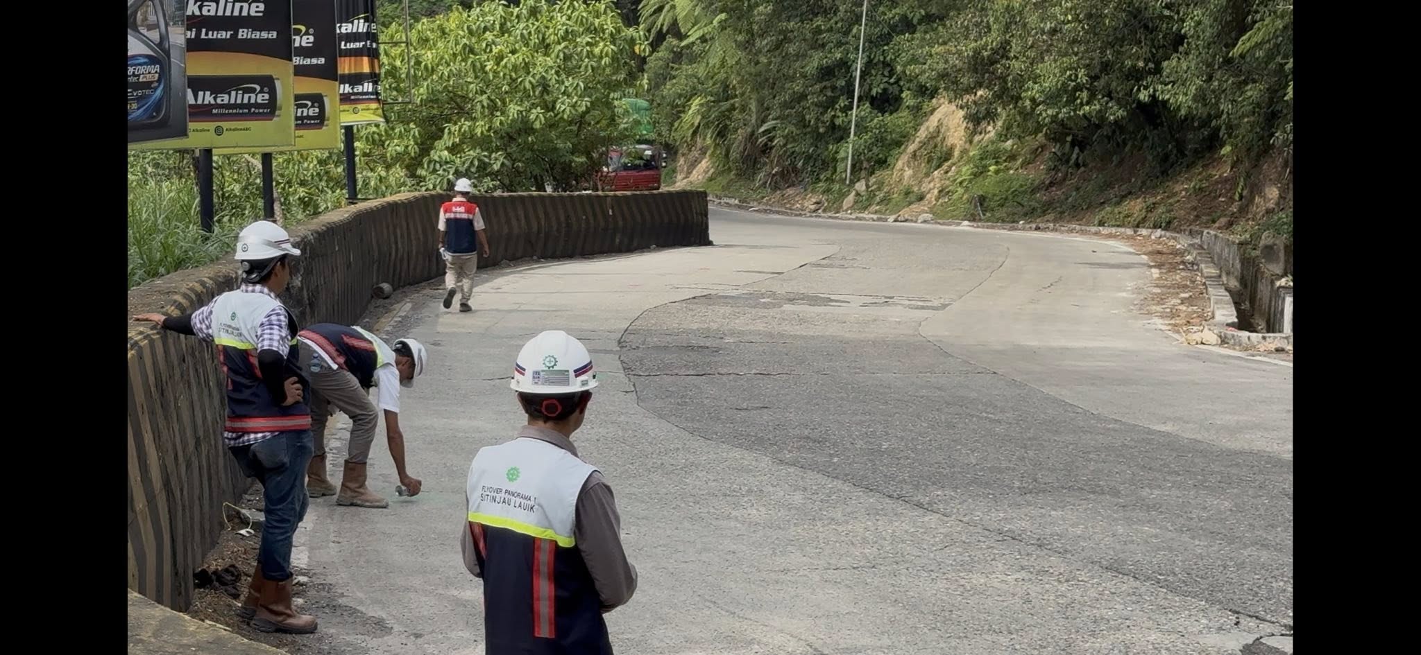 Terlihat pekerja mengenakan rompi bertuliskan &ldquo;Flyover Panorama 1 Sitinjau Lauik&rdquo;, melakukan pengukuran dan penandaan di badan jalan yang akan ditutup 21-23 Juli 2025. (Foto: Sitinjau Lauik Channel)
