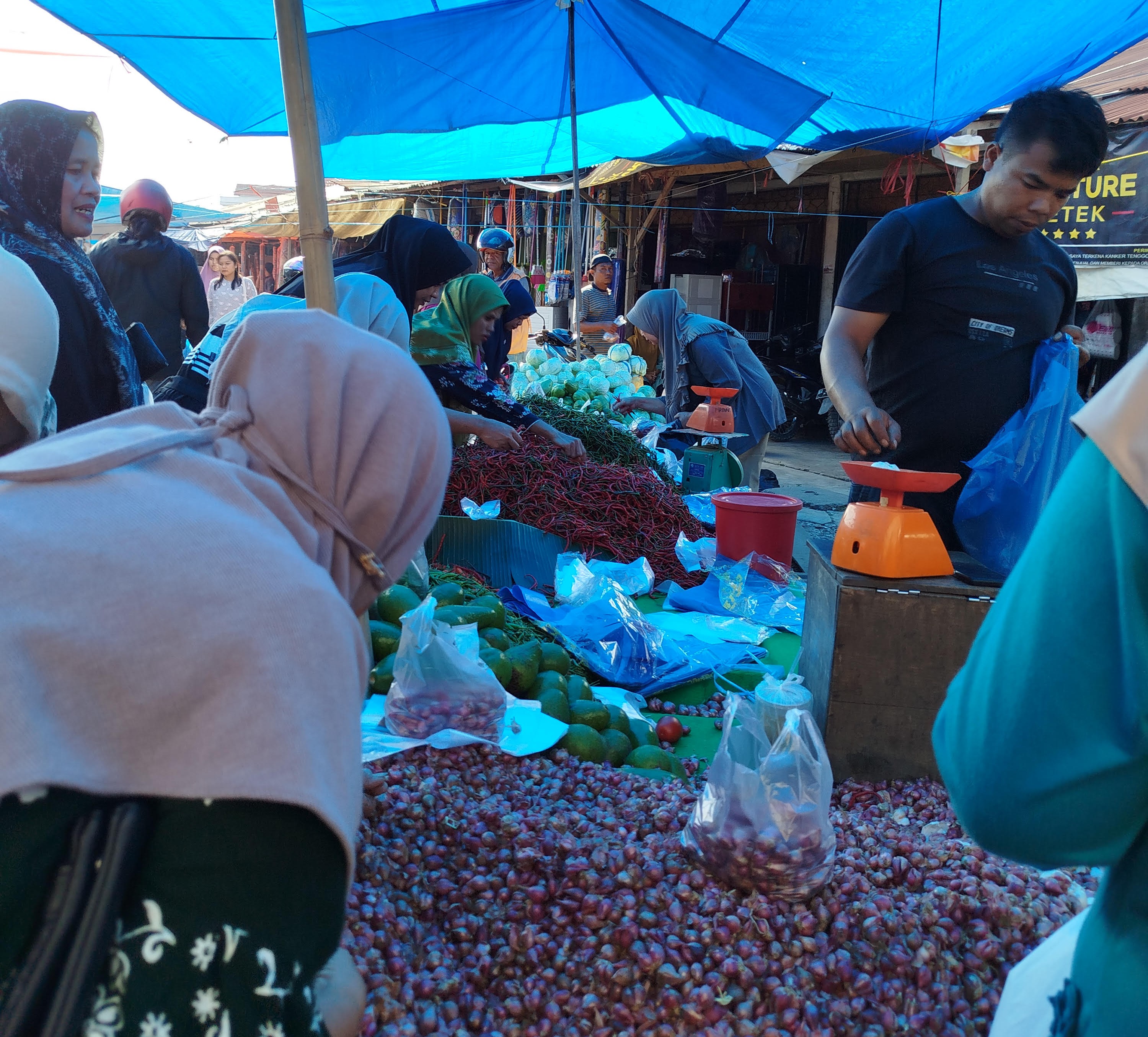 Sejumlah pembeli sedang membeli kebutuhan bahan pokok di Pasar Pulau Punjung, Minggu (20/7).