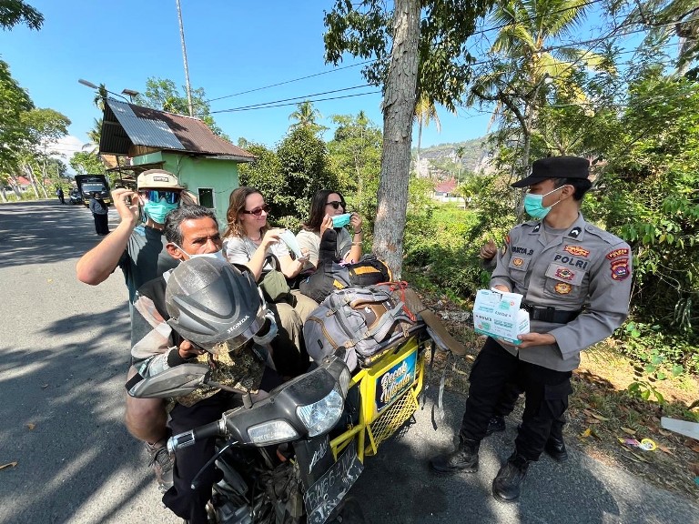 ANTISIPASI KABUT ASAP: Salah seorang anggota Polres Limapuluh Kota membagikan masker kepada warga dan wisatawan di Lembah Harau, Kabupatan Limapuluh Kota, kemarin.(SY RIDWAN/PADEK)