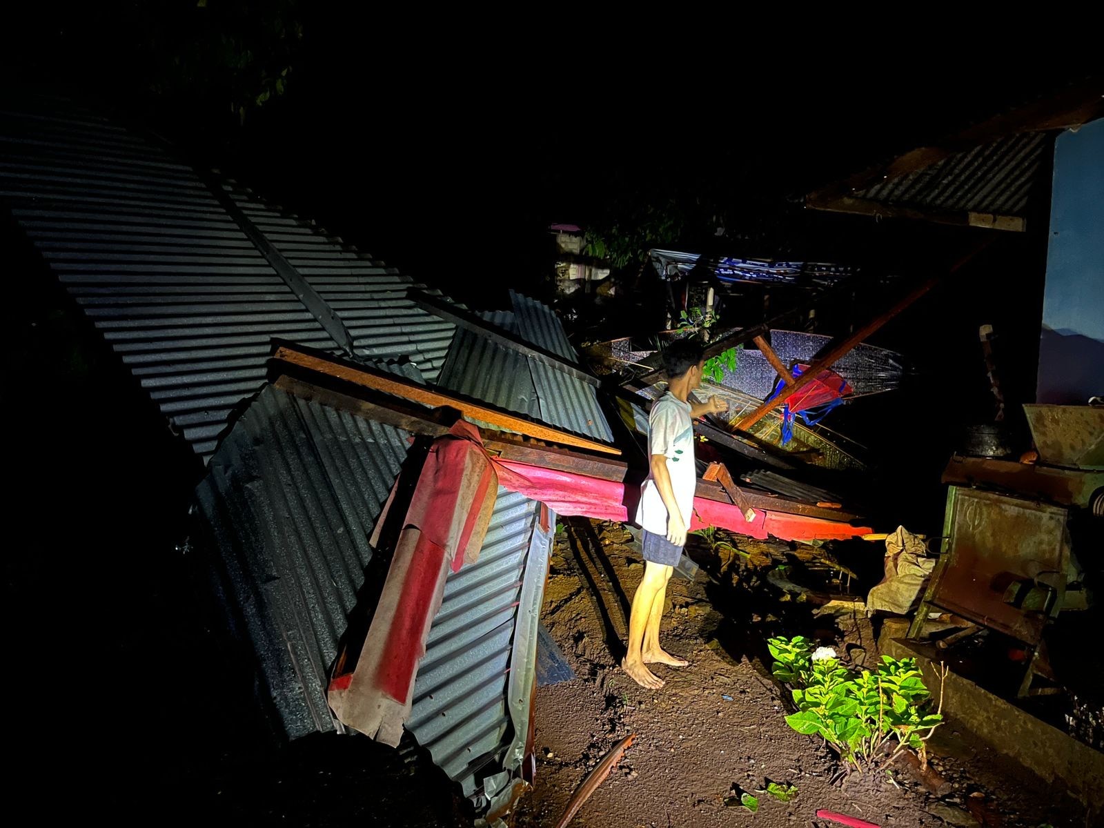 PORAK PORANDA: Seorang warga Jorong Kapalobukik, Nagari Batupayuang, Kabupaten Limapuluh Kota memperlihatkan atap rumahnya yang diterjang puting beliung, Minggu (27/7) sore.(SY RIDWAN/PADEK)