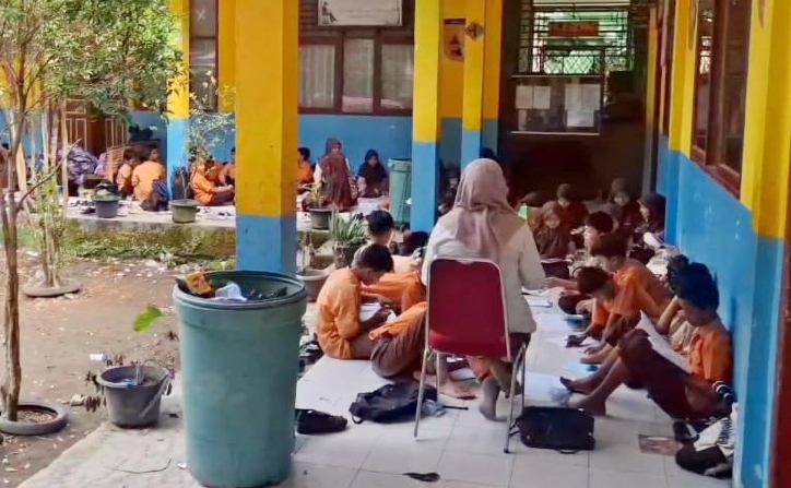TETAP SEMANGAT: Para siswa dan guru di SDN 05 Sungailimau tetap menjalani proses belajar mengajar di teras karena ruang kelas yang digembok oleh penjaga sekolah, kemarin.(ARIS PRIMA G/PADEK)