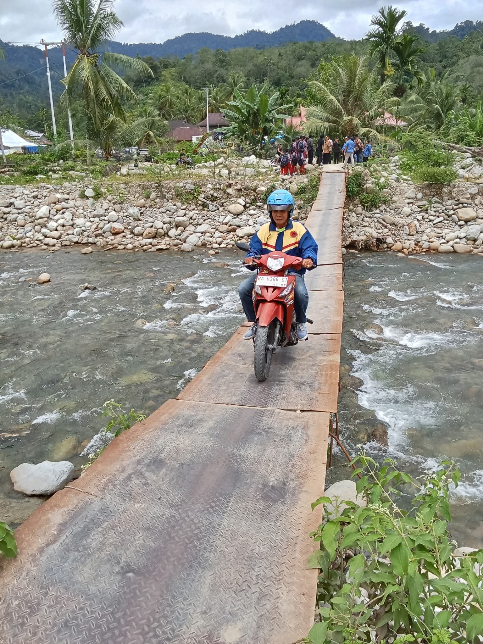 BAKAL DIPERBAIKI: Kondisi jembatan darurat yang melintasi Sungai Batang Tambang di Nagari Koto Rawang, masih digunakan warga meski tanpa pengaman.(DOKUMEN M. JONI UNTUK PADEK)