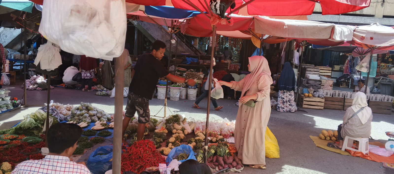 Salah seorang pedagang di Pasar Raya Padang saat melayani pembeli, Senin (4/8).