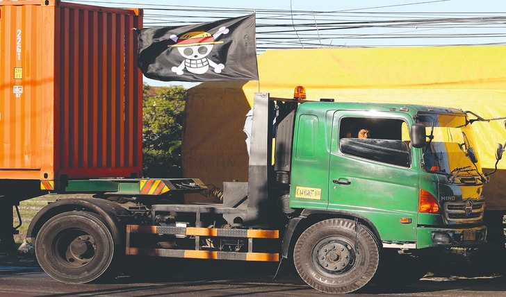 TENGAH MENJAMUR: Sebuah truk terlihat melintas di Jalan Lingkar Timur, Sidoarjo, Jawa Timur, dengan bendera One Piece terpasang kemarin (2/8).(ANGGER BONDAN/JAWA POS)