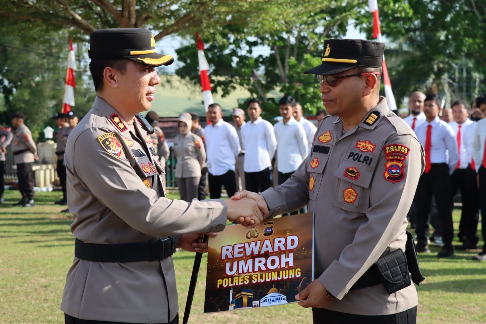 Kapolres Sijunjung, AKBP Willian Harbensyah menyerahkan hadiah umrah gratis kepada Kabag SDM Polres Sijunjung, AKP Darmansyah.
