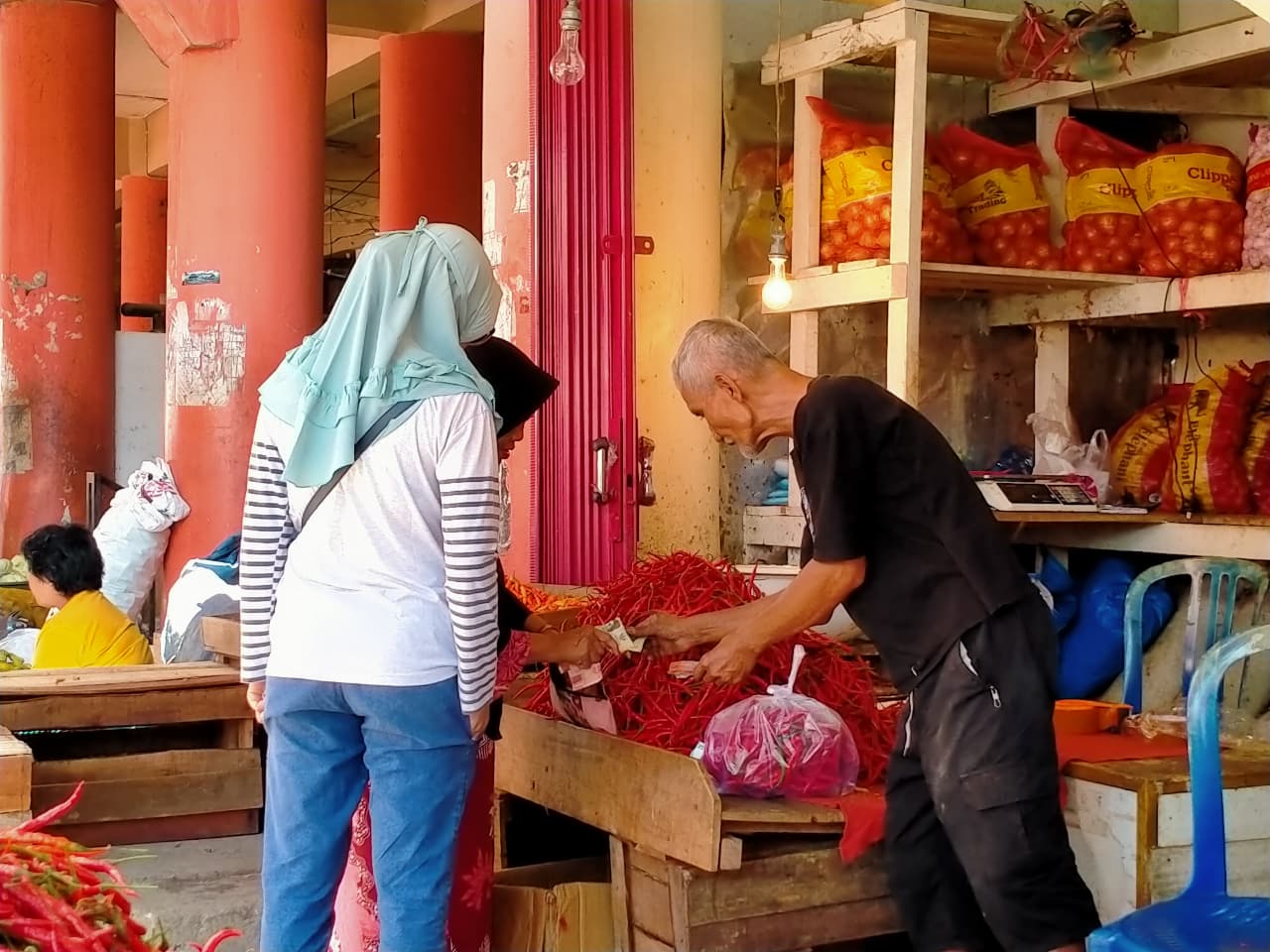 Salah seorang pedagang kebutuhan pokok di Pasar Raya Padang sedang melayani pembeli, kemarin.
