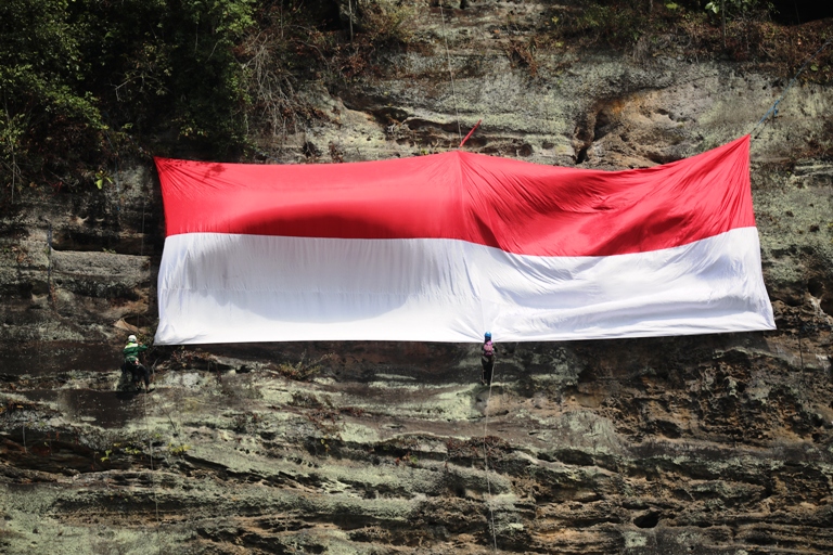 SEMANGAT KEMERDEKAAN: Bendera Merah Putih raksasa berukuran 7x16 meter berhasil dikibarkan di dinding cadas Tebing Andaleh, Nagari Andaleh, Kecamatan Luhak, Limapuluh Kota, peringati HUT ke-80 RI.