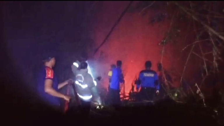 SULIT DIJANGKAU: Petugas Damkar Kabupaten Limapuluh Kota berusaha memadamkan api yang membakar rumpun bambu di lereng Jorong Ikua Parit, Nagari Limbanang, Kecamatan Suliki, Senin malam (18/8).
