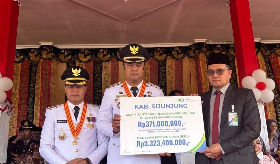 Kepala BPJS Ketenagakerjaan Solok Maulana Anshari Siregar (kanan) menyerahkan secara manfaat program perlindungan sosial berupa beasiswa pendidikan dan BSU kepada Bupati Sijunjung Benny Dwifa.