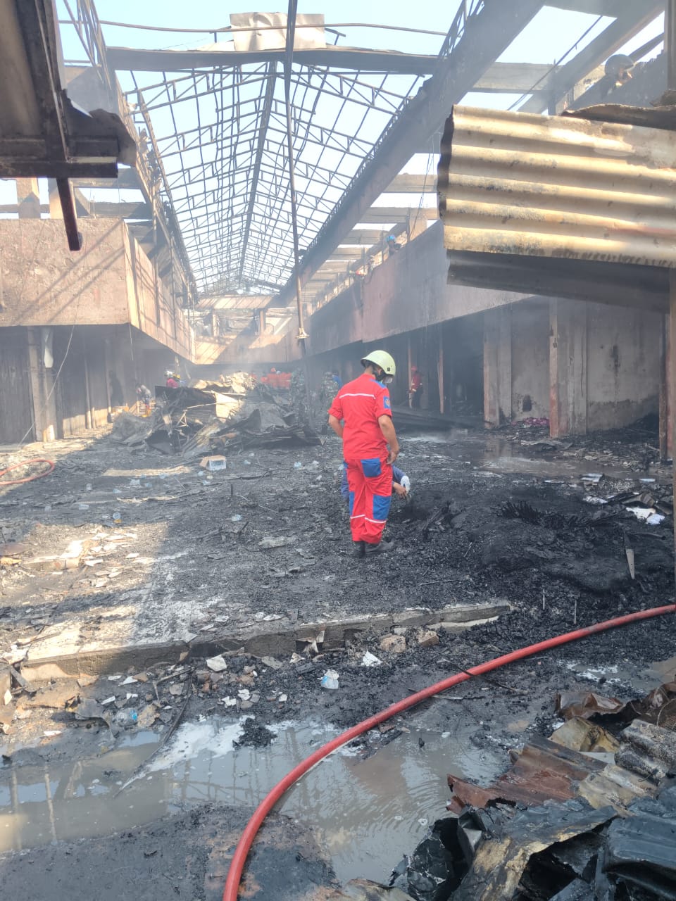 Petugas pemadam saat menyisir bagian dalam Pasar Payakumbuh yang terbakar.