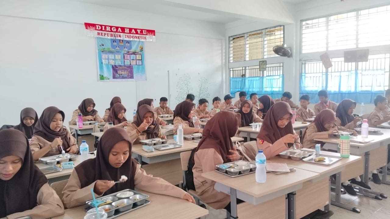 SENANG: Para siswi SMP Negeri 39 Padang terlihat sedang menikmati MBG.