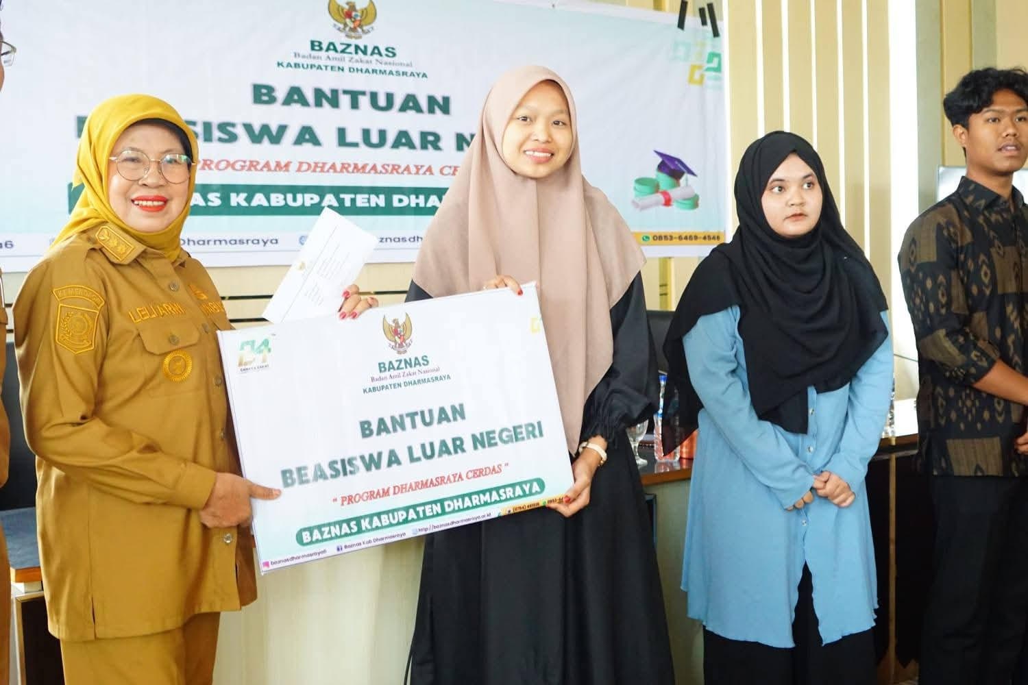 BANTUAN: Wakil Bupati Dharmasraya, Leli Arni, menyerahkan bantuan biaya kuliah ke luar negeri kepada mahasiswa penerima di Aula Kantor Bupati Dharmasraya.