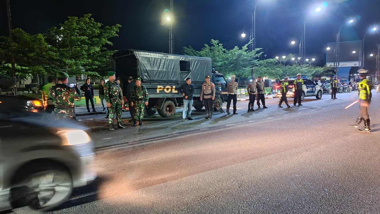 CEGAH GANGGUAN: Petugas gabungan dari Polres Sijunjung, TNI, Satpol PP, dan instansi terkait berjaga di Jalan M. Yamin, depan Taman Kota Muaro Sijunjung, Selasa (2/9) malam.