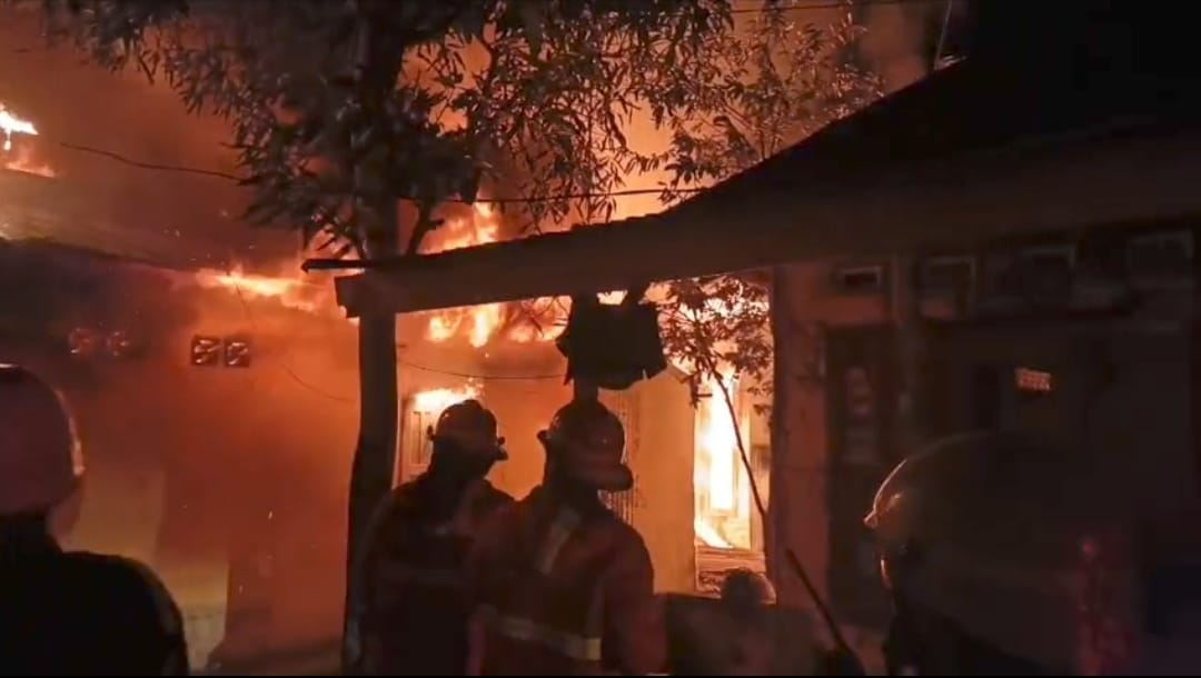 Tim Dinas Damkar Kota Padang berusaha memadamkan api yang membakar 4 rumah hunian di  Kampung Lapai, Kecamatan Nanggalo, Kota Padang, Rabu malam (10/9/2025).