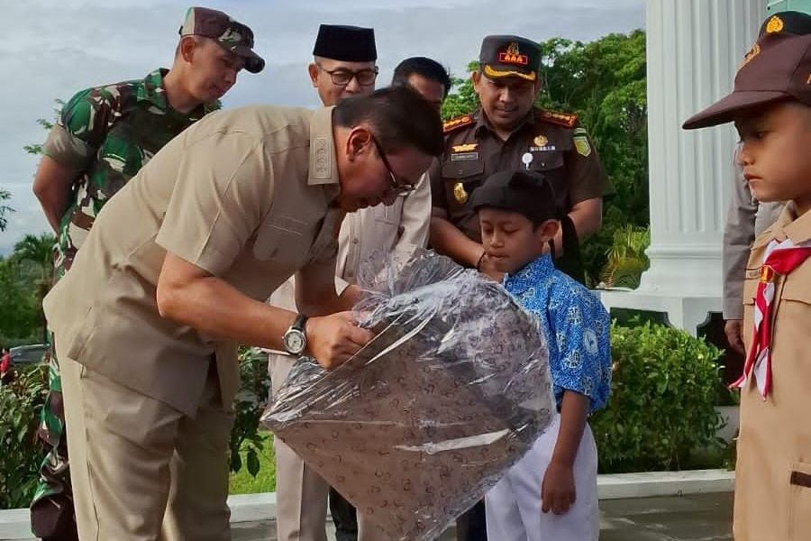 BENTUK DUKUNGAN: Wali Kota Bukittinggi, Ramlan Nurmatias, menyerahkan paket seragam sekolah gratis kepada salah satu pelajar SD di Halaman Balaikota Bukittinggi, Kamis (11/9).