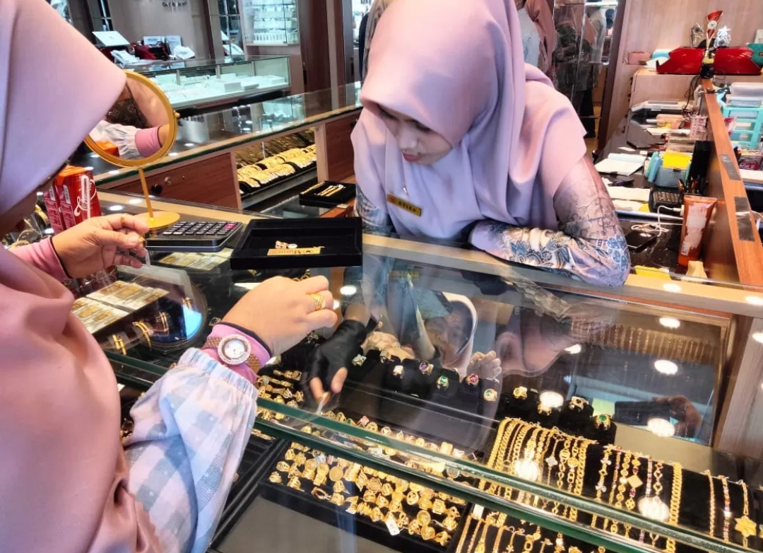 Salah seorang karyawan toko emas di Pasar Raya Padang sedang melayani pelanggan, beberapa waktu lalu. (Foto: Endang Pribadi.)