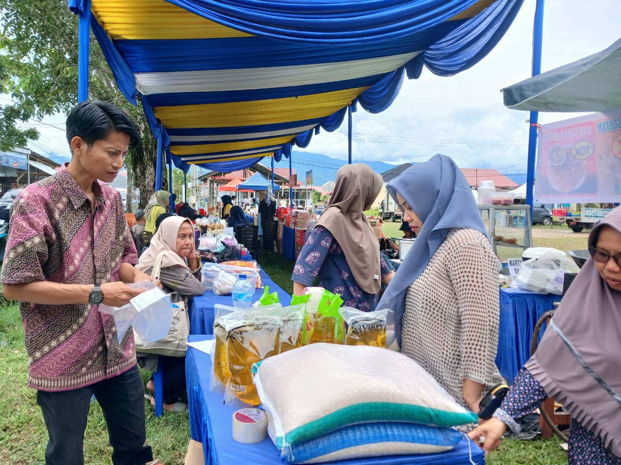 Warga berbelanja bahan pokok di Pasar Murah yang diadakan di Lapangan Voli RW 03 RT 01 Kelurahan Bungopasang Kecamatan Kototangah, Padang, Rabu (17/9).