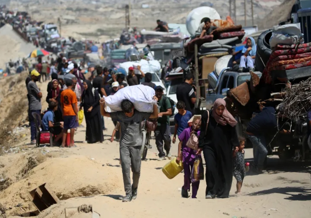 Warga Palestina dari Kota Gaza bergerak ke selatan membawa barang-barang mereka, di jalan pesisir dekat kamp pengungsi Nuseirat di Jalur Gaza tengah, 19 September 2025.(Foto: Eyad Baba/AFP)